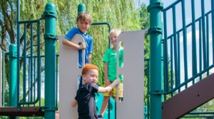 Three campers playing at a playground.