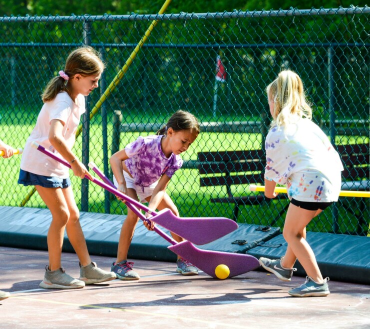 Three campers playing hockey.