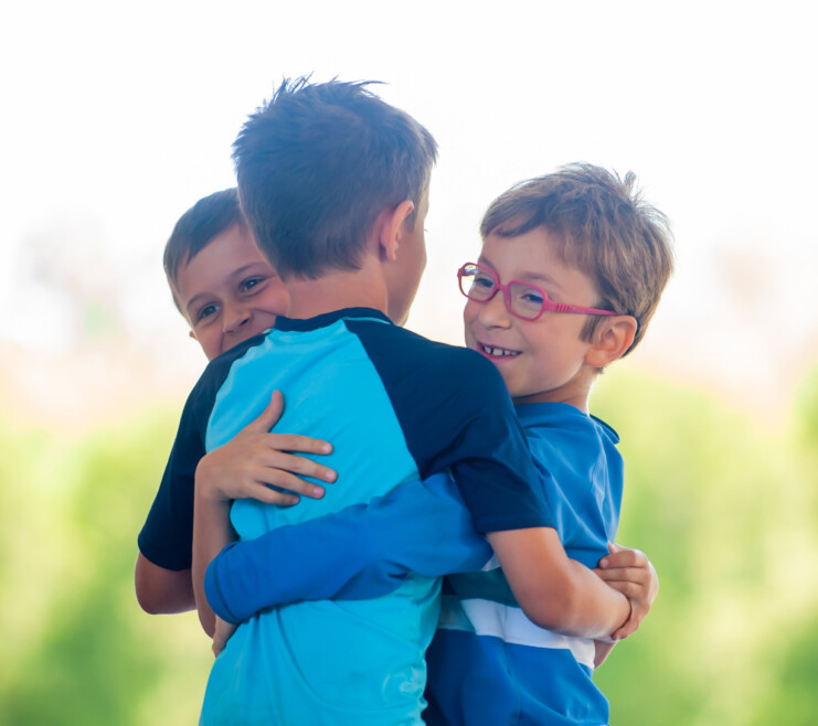 Three campers hugging.