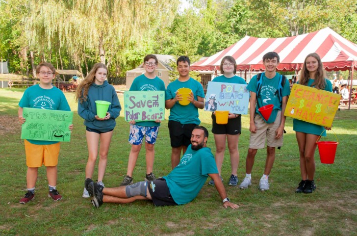 A group of campers holding posters for a fundraiser.