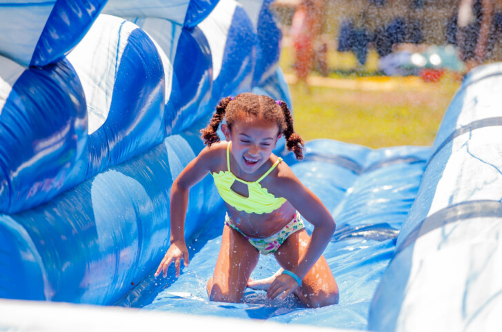 A camper going down an inflatable water slide.